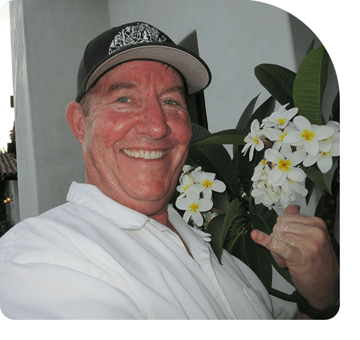 A man holding flowers in his hand and smiling.